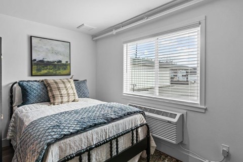 a small bedroom with a bed and a window